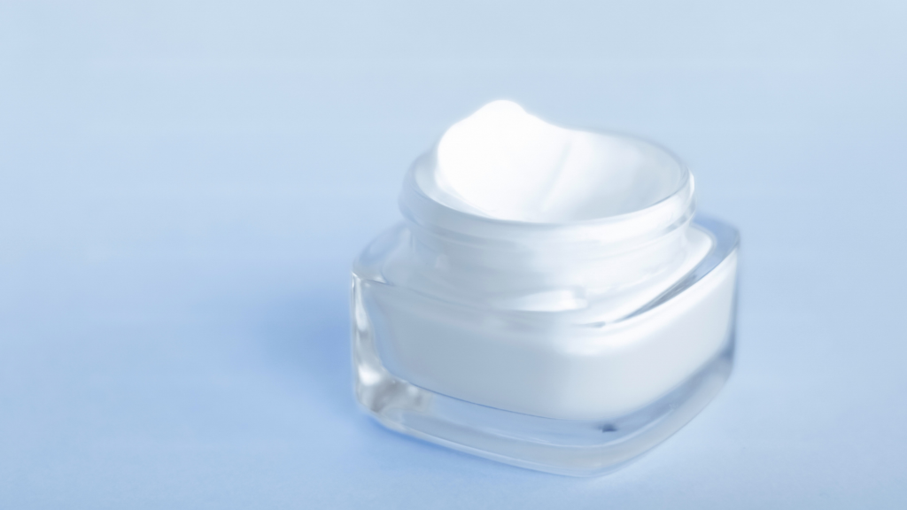 close up of open moisturizer on light blue background